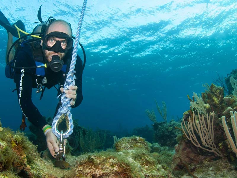 Photo of a man installing a boat mooring underwater